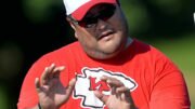 eugene chung decked out in kansas city chiefs gear makes a coaching point during a training camp practice